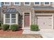 Two story townhome with stone exterior, two car garage, and landscaping at 9510 Birkwood Ct, Charlotte, NC 28278