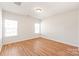 Bright bedroom featuring light wood flooring and two windows at 9510 Birkwood Ct, Charlotte, NC 28278