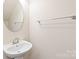 Small bathroom with pedestal sink and oval mirror at 9510 Birkwood Ct, Charlotte, NC 28278