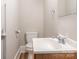 Simple bathroom with a toilet, sink, and wood-look flooring at 1411 Lineberger Ave, Gastonia, NC 28052