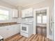 White kitchen with updated appliances and view into dining area at 1411 Lineberger Ave, Gastonia, NC 28052