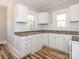 White kitchen cabinets, tile backsplash, and light wood floors at 1411 Lineberger Ave, Gastonia, NC 28052