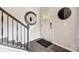 Modern entryway with dark wood staircase, circular mirror, and white door at 3248 Stelfox St, Charlotte, NC 28262