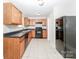 Kitchen with wood cabinets, black appliances, and tile flooring at 612 Carybrook Ct, York, SC 29745