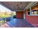 Covered front porch with brick flooring and wrought iron railing at 1218 E Marion St, Shelby, NC 28150