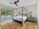 Spacious main bedroom with a four-poster bed, pool view, and large windows at 1401 Heather Ln, Charlotte, NC 28209