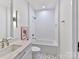 Clean bathroom with white tile, bathtub and updated fixtures at 1401 Heather Ln, Charlotte, NC 28209