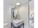 Modern bathroom with marble vanity, arched mirror, and black matte fixtures at 1401 Heather Ln, Charlotte, NC 28209