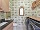 Laundry room with washer, dryer, and charming wallpaper at 1401 Heather Ln, Charlotte, NC 28209