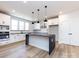 Modern kitchen with white cabinets, dark countertops, stainless steel appliances, and an island at 1512 Levy Way, Charlotte, NC 28205