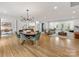 Open concept dining room with hardwood floors, chandelier, and living room view at 4220 Brookfield Dr, Charlotte, NC 28210