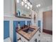 Bathroom with a rustic wood vanity, blue walls, and marble-style floors at 215 Mellwood Dr, Charlotte, NC 28214