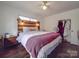 Bedroom with rustic wood headboard, ceiling fan, and hardwood floors at 215 Mellwood Dr, Charlotte, NC 28214