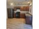 Kitchen features brown cabinets, stainless steel appliances, and light wood flooring at 5835 Natick Dr, Charlotte, NC 28214