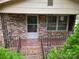 Brick front porch with iron railings and tiled floor at 82 Allen Pond Rd, Wadesboro, NC 28170