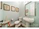 Elegant powder room with pedestal sink and framed art at 131 Boyce Rd, Charlotte, NC 28211