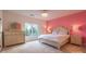 Spacious bedroom with pink accent wall and large window at 17418 Sailors Watch Pl, Cornelius, NC 28031