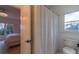 Full bathroom with toilet, shower, and bedroom view at 17418 Sailors Watch Pl, Cornelius, NC 28031