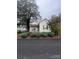 Charming yellow cottage with front porch and well-manicured landscaping at 2 Elm St, Lancaster, SC 29720