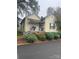 Inviting yellow cottage with a porch, steps, and lush landscaping at 2 Elm St, Lancaster, SC 29720