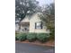 Quaint yellow cottage featuring a porch and neatly landscaped yard at 2 Elm St, Lancaster, SC 29720