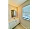 Bathroom with white vanity, mirror, and window overlooking trees at 3312 Heathstead Pl, Charlotte, NC 28210