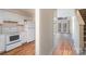 View of the kitchen with white appliances, wood floors, and view of the living area at 3312 Heathstead Pl, Charlotte, NC 28210