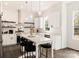 Modern white kitchen with stainless steel appliances and an island with seating at 9000 Boyd Dr, Matthews, NC 28105