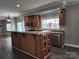 Kitchen island with wood cabinets, stainless steel appliances, and a view to backyard at 129 Burning Ln, Stony Point, NC 28678