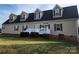 Beige house with a gray roof, dormer windows, and a white porch at 129 Burning Ln, Stony Point, NC 28678