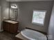 Bathroom with double sinks, a garden tub, and a window at 129 Burning Ln, Stony Point, NC 28678