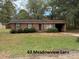 Brick ranch home with attached garage and mature landscaping at 220 Woodside Dr, Wadesboro, NC 28170