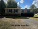 Single-wide mobile home with gray siding and a gravel driveway at 220 Woodside Dr, Wadesboro, NC 28170