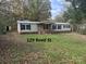 Single-wide mobile home with vinyl siding and a small shed at 220 Woodside Dr, Wadesboro, NC 28170