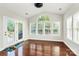 Bright sunroom featuring hardwood floors, multiple windows, and French doors leading to a deck at 16404 Grassy Creek Dr, Huntersville, NC 28078