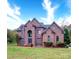 Brick two-story house with a large front yard and mature trees at 119 Plantation Dr, Mooresville, NC 28117