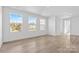 Bright bedroom with three large windows, light wood floors, and a hallway at 183 Sugar Hill Rd, Troutman, NC 28166