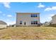 Rear view of a two-story house with light beige siding, and a grassy yard at 183 Sugar Hill Rd, Troutman, NC 28166