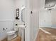 Powder room with white pedestal sink and wood floors at 8004 Brookbank Dr, Charlotte, NC 28269