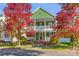 Two-story green house with wrap around porch, brick steps and landscaping at 14108 Tooley St, Huntersville, NC 28078