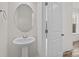 Simple powder room with pedestal sink and round mirror at 655 District Ct # 18, Fort Mill, SC 29708