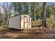 Large storage shed nestled in a wooded area of the backyard at 108 W Maryland Ave, Bessemer City, NC 28016