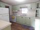 Kitchen with light green cabinets and new flooring at 455 Pine Lake Dr, Troy, NC 27371