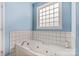 Bathroom with jetted tub and a large block window at 6650 Long Branch Rd, Salisbury, NC 28147