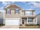 Two-story house with a white garage door and brown siding at 1628 Savory Ln, Charlotte, NC 28216