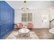 Living room with blue accent wall, pink chairs, and a statement chandelier at 1628 Savory Ln, Charlotte, NC 28216