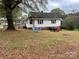 Side yard view of white house with seating area at 210 Lincoln St, Albemarle, NC 28001