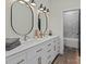 Bathroom with double vanity, white cabinets, and oval mirrors at 4180 2Nd Ne St, Hickory, NC 28601