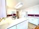 L-shaped kitchen with white cabinets and modern appliances at 5486 Kershaw Camden Hwy, Heath Springs, SC 29058