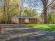 One-story brick house with a gravel driveway and lush green landscaping at 8745 Pine Tree Cir, Charlotte, NC 28278